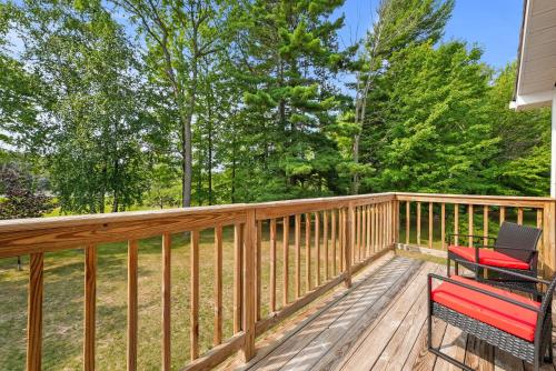 a deck with two chairs and a bench on it at LAKEFRONT PARADISE 4 bedroom Home w direct lake access, Pets OK in Traverse City