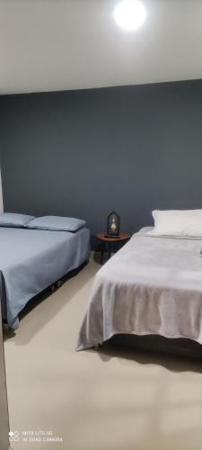 1 dormitorio con 2 camas y pared negra en Apartaestudio Maridiaz, en Pasto