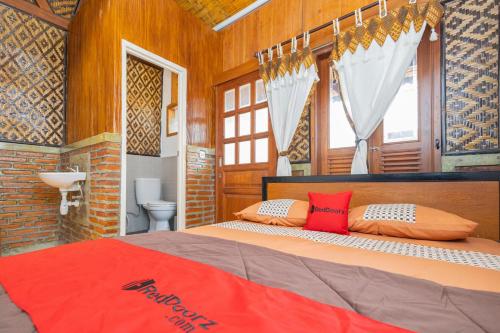 a bedroom with a bed with two pillows on it at RedDoorz Syariah At Wisma Djokorio Poncokusumo in Gubukklakah