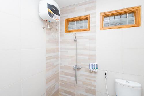 a shower stall in a bathroom with a toilet at RedDoorz Syariah At Wisma Djokorio Poncokusumo in Gubukklakah