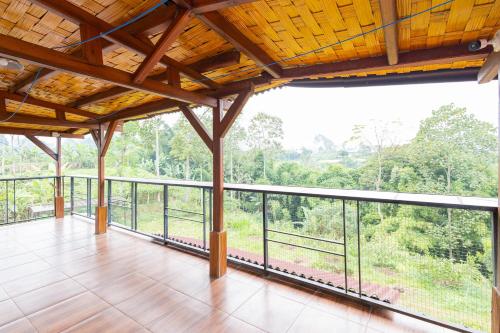 a balcony with a view of the forest at RedDoorz Syariah At Wisma Djokorio Poncokusumo in Gubukklakah