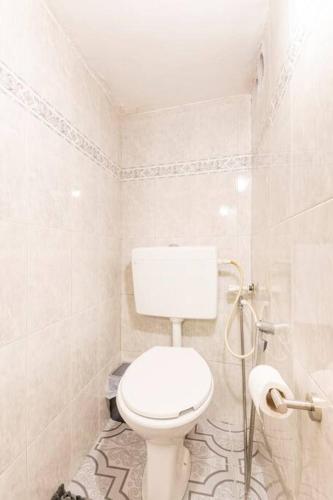 a white bathroom with a toilet and a shower at family home in acre in ‘Akko