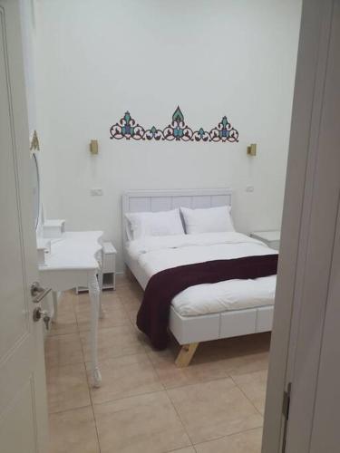 a bedroom with a white bed and a white table at family home in acre in ‘Akko