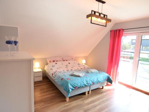 a bedroom with a bed with a blue comforter at Bright and friendly furnished holiday home in Kopalino in Kopalino