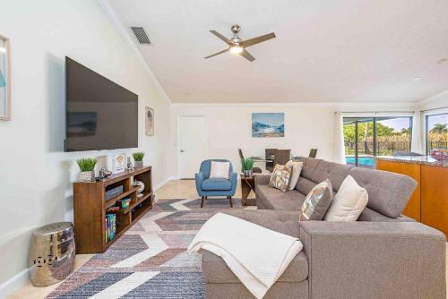 a living room with a couch and a flat screen tv at 4/3.5 House with pool- Boynton Beach, FL. in Boynton Beach
