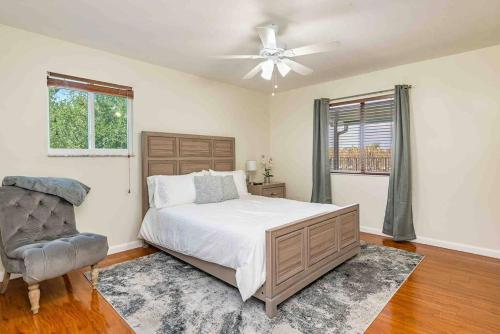 - une chambre avec un lit, un ventilateur et une chaise dans l'établissement 4/3.5 House with pool- Boynton Beach, FL., à Boynton Beach