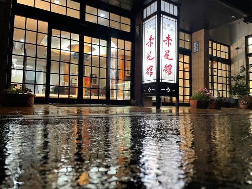 a building with large windows and a wet floor at Gokayama Onsen Akaokan in Nanto
