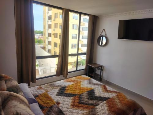 a bedroom with a bed and a large window at Ubicacion y comodidad en una Suit in Manta