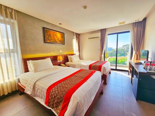 a hotel room with two beds and a window at Le Botum Hotel in Phnom Penh