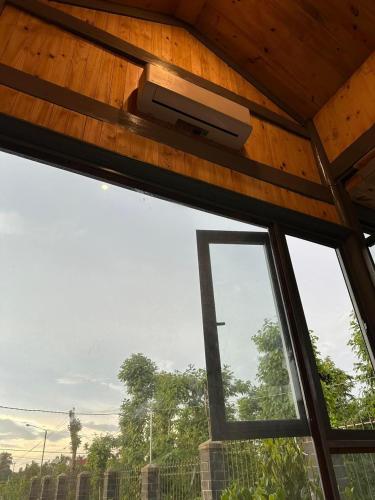 una ventana en una casa con TV en el techo en Ylang Farmstay, en Buon Ma Thuot