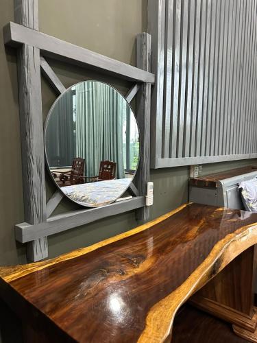 a wooden table with a mirror on the wall at Ylang Farmstay in Buon Ma Thuot