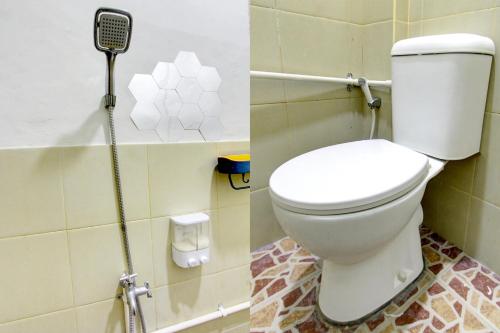 ein Badezimmer mit einem weißen WC und einer Dusche in der Unterkunft OYO 92825 Kamar Lombok in Kuripan