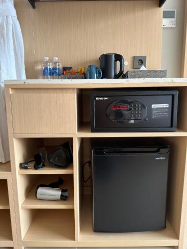 a microwave in a wooden shelf with a microwave oven at The Cam Ranh Resort all Luxury Service in Miếu Ông