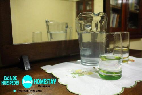 a glass of water sitting on a table in front of a mirror at Homestay Matagalpa in Matagalpa