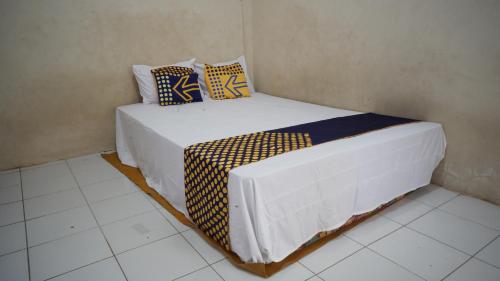 1 Schlafzimmer mit 2 Betten mit blauen und gelben Kissen in der Unterkunft SPOT ON 92860 Hunian 99 in Banyuwangi