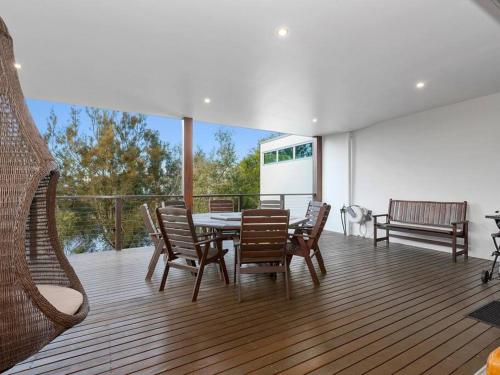 a dining room with a table and chairs on a deck at Friday Island Cabarita in Cabarita Beach