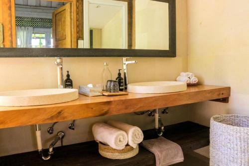 a bathroom with two sinks and a mirror at Chanteak Bali in Jimbaran