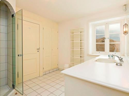 a white bathroom with a sink and a shower at Heidehaus in Kampen