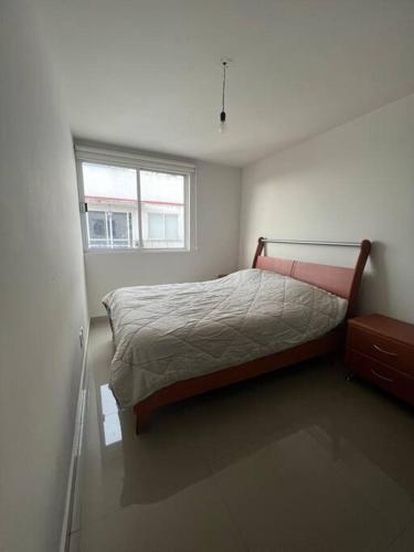 Departamento en Coyoacan في مدينة ميكسيكو: غرفة نوم صغيرة بها سرير ونافذة