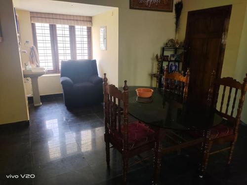 a living room with a table and a blue chair at Entire 4 Bedroom villa in Trivandrum