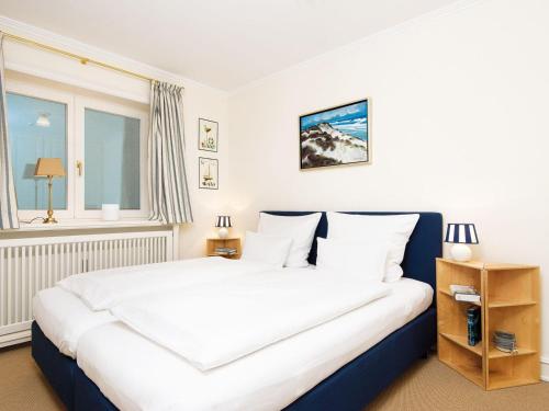 ein Schlafzimmer mit einem großen Bett mit weißer Bettwäsche und einem Fenster in der Unterkunft Rasmus 1 in Kampen