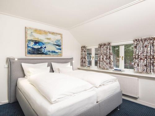 1 dormitorio con 1 cama blanca y 2 ventanas en Sonnenhof-F en Kampen