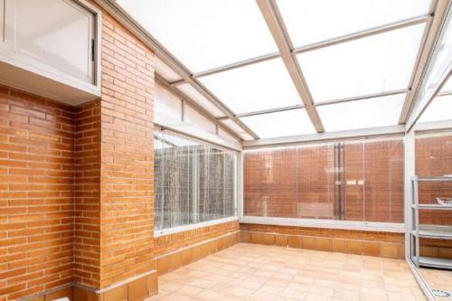 una stanza vuota con un muro di mattoni e finestre di Impresionante apartamento de 4 dormitorios 3 baños y 2 plazas de garaje a Madrid