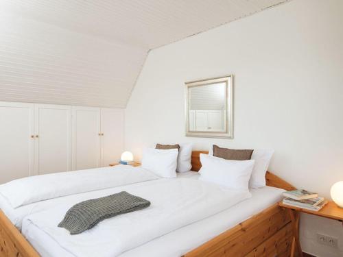 a white bedroom with a large bed with white pillows at Lukas-Hues in Kampen