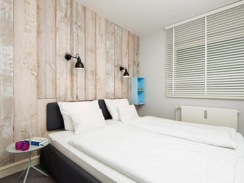 a bedroom with a large white bed and a table at Kaeptn-Cook-4 in Kampen