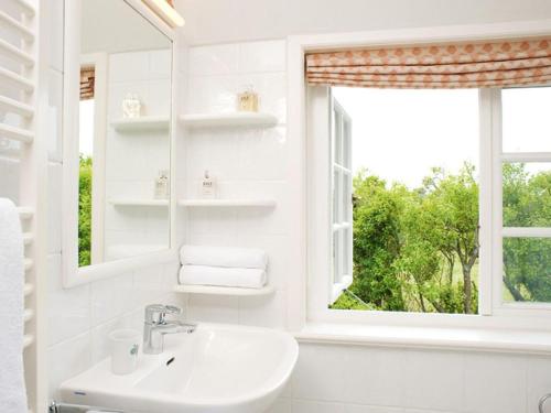 uma casa de banho branca com um lavatório e uma janela em Drosselhues-Sued em Kampen