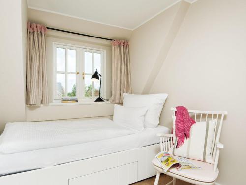een witte slaapkamer met een wit bed en een stoel bij Min-Go in Kampen