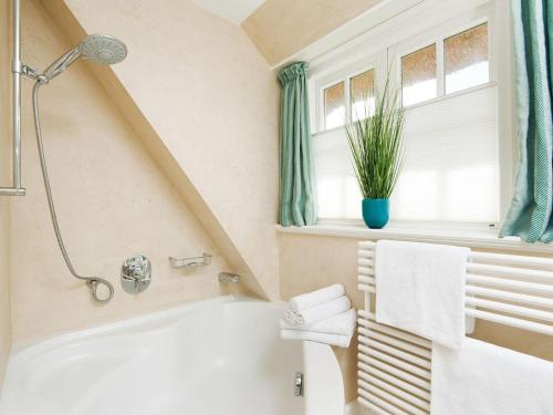 a bathroom with a white tub and a window at Min-Go in Kampen