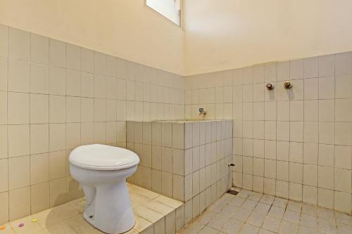 a bathroom with a toilet in a tiled room at OYO 92885 Satriafi 2 Hotel in Yogyakarta