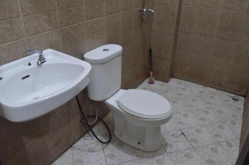 ein Badezimmer mit einem weißen WC und einem Waschbecken in der Unterkunft OYO 92880 Wisma Nusantara in Manado