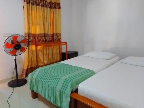 Hotel arugambay beach inn resort tesisinde bir odada yatak veya yataklar