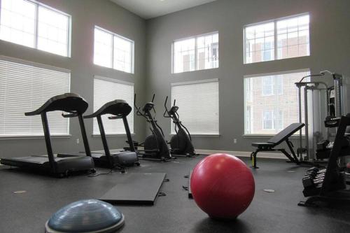 un gimnasio con bicicletas estáticas y una bola roja en el suelo en Stylish and Spacious, close to the Hospital. en Fort Wayne