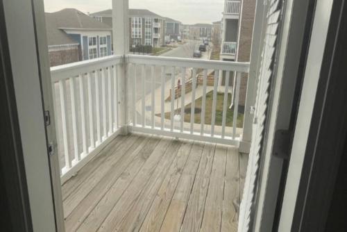 Une porte ouverte s'ouvre sur un balcon doté d'une terrasse en bois. dans l'établissement Stylish and Spacious, close to the Hospital., à Fort Wayne