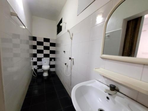 y baño con lavabo, espejo y aseo. en Hotel arugambay beach inn resort, en Arugam Bay