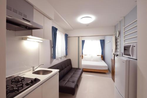 a small apartment with a couch and a kitchen with a bed at Hostel Inn Tokyo Asakusa East in Tokyo