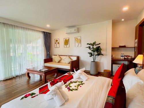 a hotel room with two beds and a couch at Aura Samui Best Beach Hotel - SHA Plus in Lamai