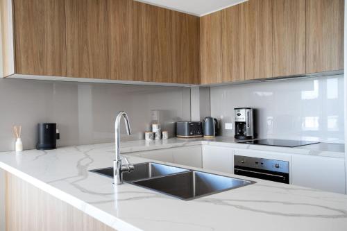 a kitchen with a sink and wooden cabinets at Harbour Sunrise in Ulladulla