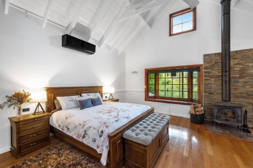 a bedroom with a large bed and a fireplace at Twin Peaks in Kangaroo Valley
