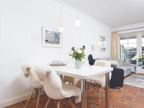 ein Wohnzimmer mit einem weißen Tisch und Stühlen in der Unterkunft Kampen-Kliff 3 in Kampen