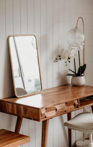 a dressing table with a mirror and a chair at Sweet Tide O Moyne in Port Fairy