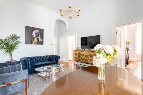 a living room with a table and a couch at Luxury Victorian House 10 mins to SF, Rose Garden & 3 Private Parking in Oakland