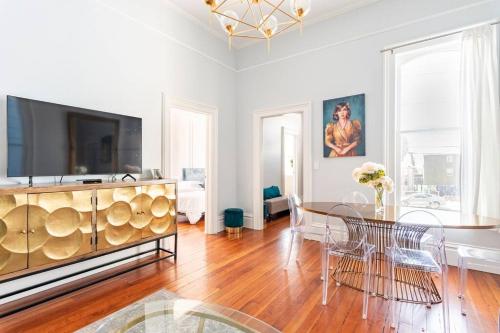 a living room with a dining table and a tv at Luxury Victorian House 10 mins to SF, Rose Garden & 3 Private Parking in Oakland