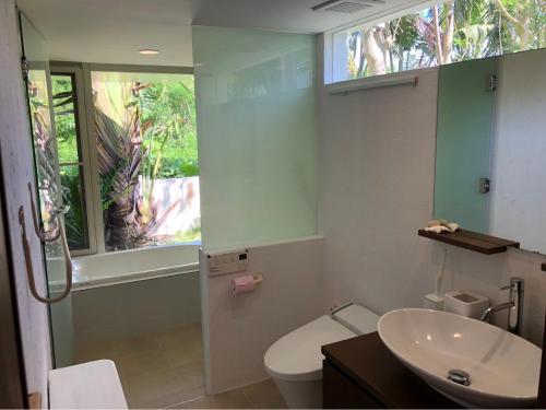 bagno con lavandino, servizi igienici e finestra di 727セブンツーセブン石垣島ベース a Isola di Ishigaki