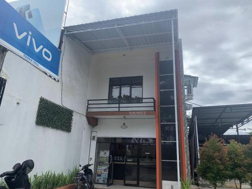 a building with a balcony on the side of it at Hotel O Penginapan Laota Syariah Near Rumah Sakit Islam Faisal Makassar in Luwuk