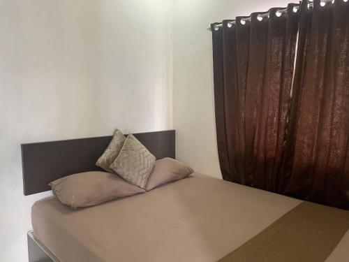 a bed with two pillows on it in a room at Hotel O Penginapan Laota Syariah Near Rumah Sakit Islam Faisal Makassar in Luwuk