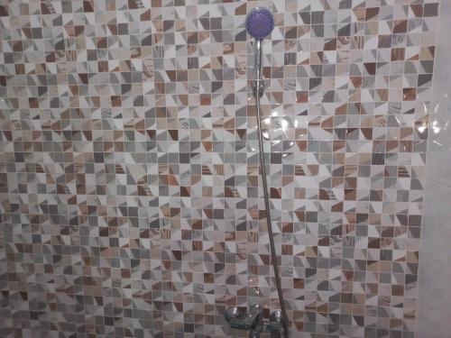 a bathroom with a shower with a tile wall at OYO 92879 Imperial Inn in Cilacap